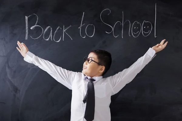 Niño con texto de Regreso a la Escuela en pizarra —  Fotos de Stock