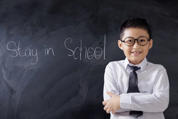 Pojke vikta händer med text av vistelse i skolan — Stockfoto
