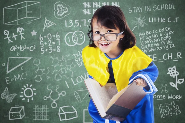 Barn med examen klänning Holding Book — Stockfoto