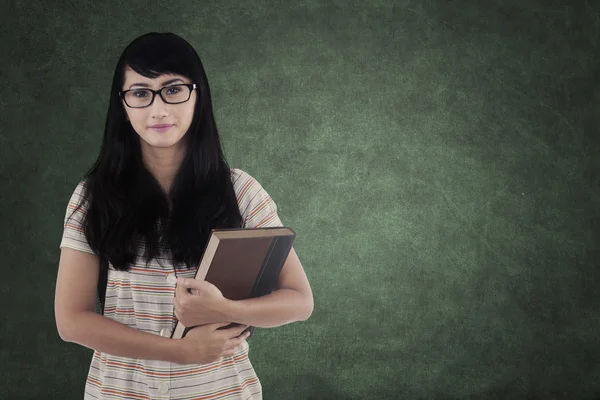 Student with black hair holding book — Stock Photo, Image