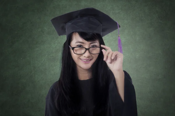 Female bachelor with graduation cap in class — Stock Photo, Image