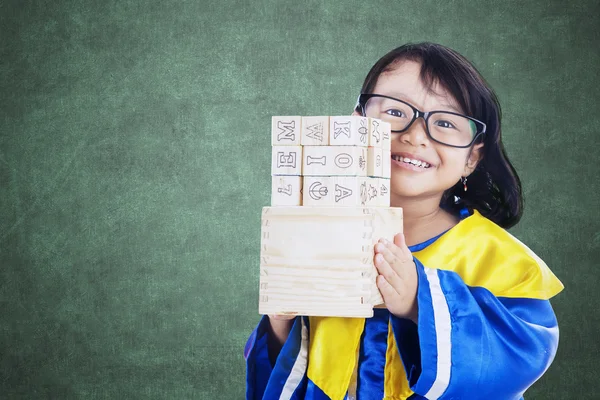 Studentessa tiene blocchi di lettere in classe — Foto Stock