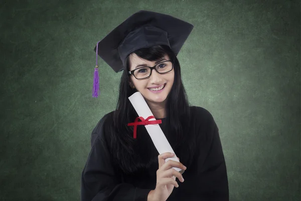 Happy bachelor holds diploma in class — Stock Photo, Image