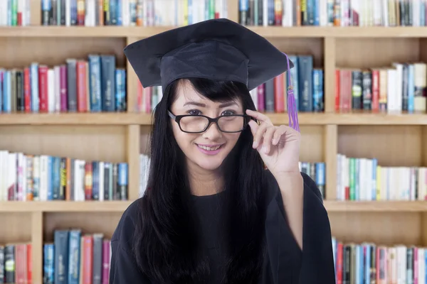 College student with graduation hat in library
