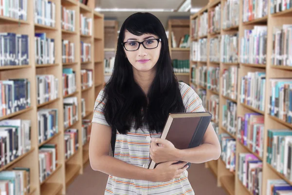 Ładna studentka z czarnymi włosami w bibliotece — Zdjęcie stockowe