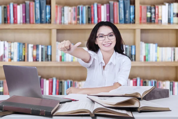 Estudante com OK assinar na biblioteca — Fotografia de Stock