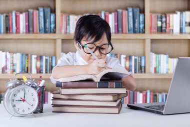 Asyalı öğrenci kütüphanede kitap yazıyor