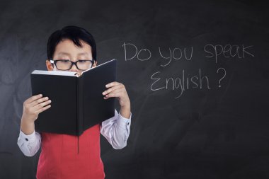 Erkek öğrenci sınıfta kitap okur