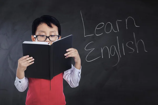 Child reads book with text Learn English — Stock Photo, Image