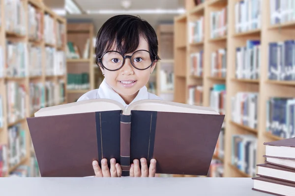 Clever schoolgirl reads science books — Stock Photo, Image