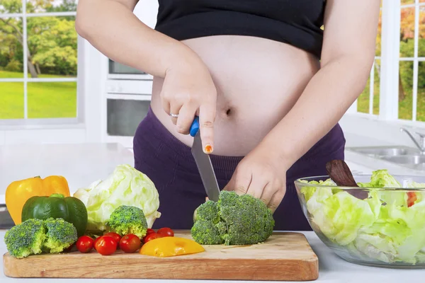Hamile kadın kesme brokoli — Stok fotoğraf