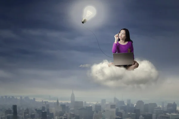 Female student with laptop on the cloud — Stock Photo, Image