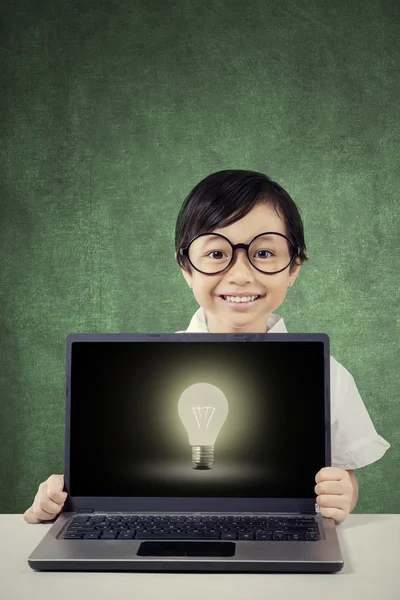 Little girl with lightbulb on laptop monitor — Stock Photo, Image