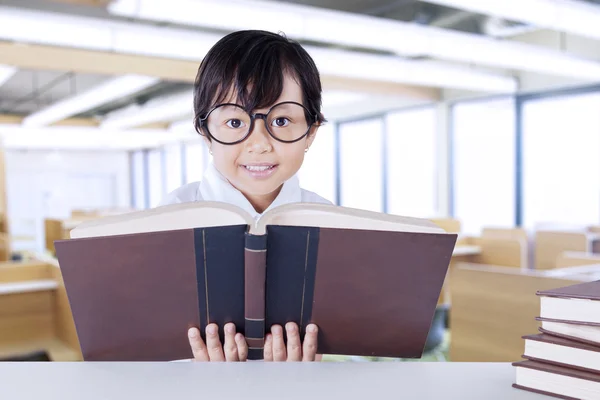 Schoolmeisje leest wetenschappelijke boeken op Bureau — Stockfoto