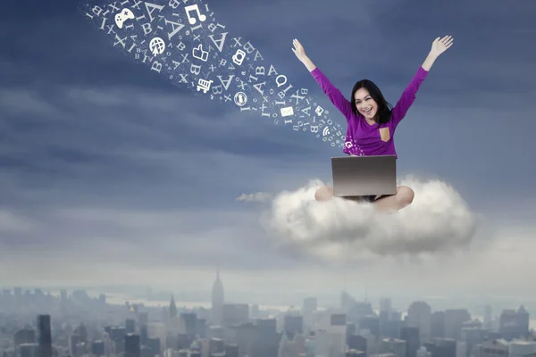 Cheerful student uses laptop on the cloud — Stock Photo, Image