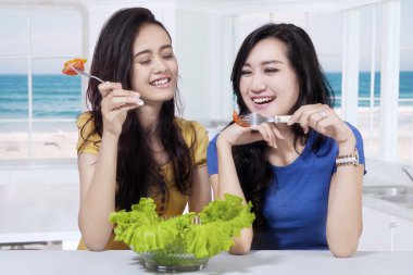 Güzel kızlar mutfakta sağlıklı yemek yiyor