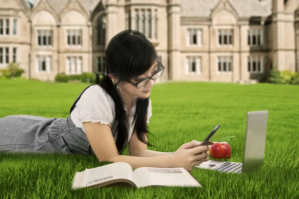 College student texting at field — Stock Photo, Image