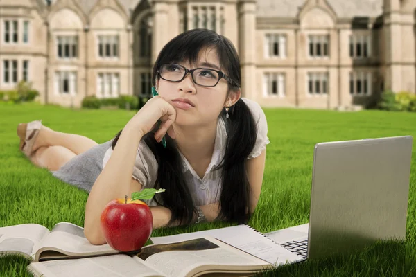 Cute schoolgirl daydreaming at park — Stock Photo, Image