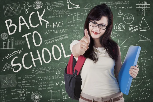 Cute schoolgirl with thumb up — Stock Photo, Image