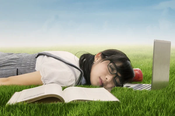 Student schläft auf Laptop im Gras — Stockfoto
