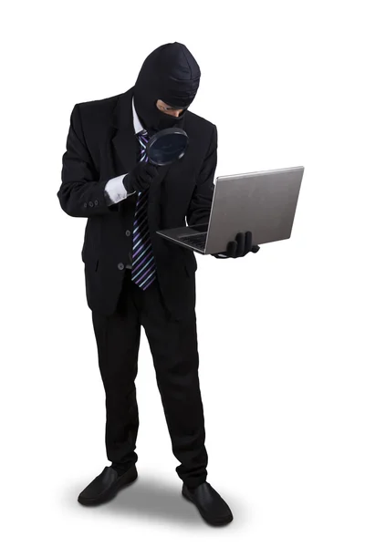 Thief with magnifier and laptop — Stock Photo, Image