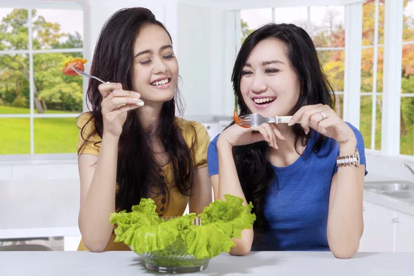 Dvě asijské dívky jí čerstvý salát — Stock fotografie