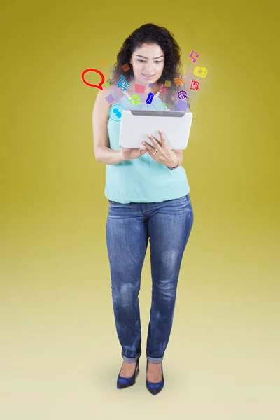 Mulher usa tablet com ícones de mídia social — Fotografia de Stock