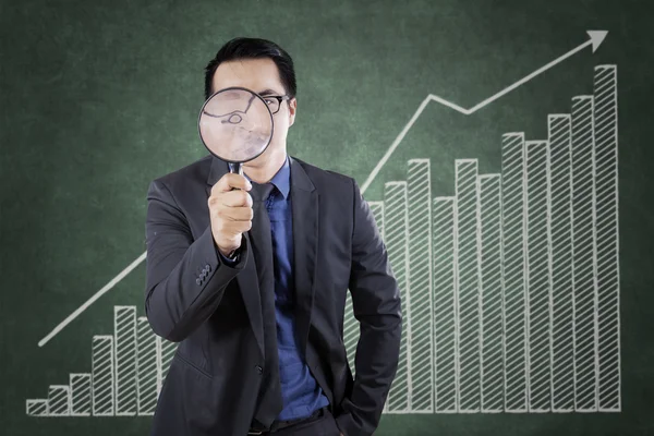 Worker with magnifying glass and graph — Stock Photo, Image