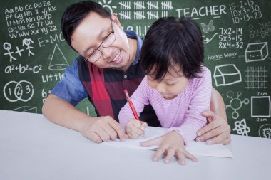 Erkek öğretmen kılavuz yazmak için bir öğrenci