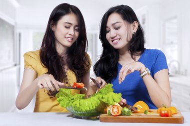 İki kadın birlikte salata hazırlık
