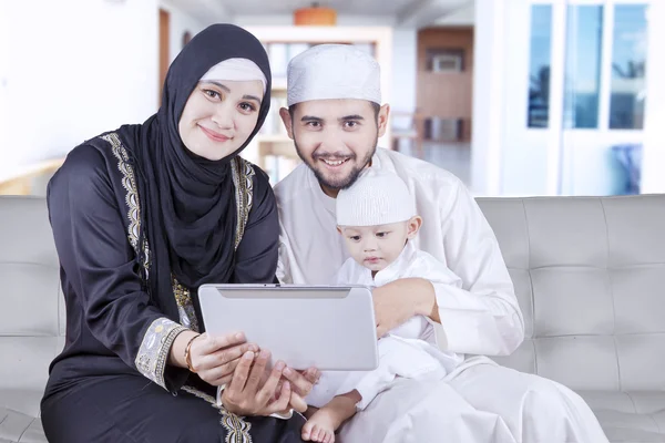 Familia árabe sosteniendo la tableta en casa — Foto de Stock