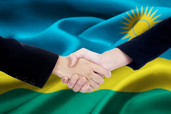 Obchodní handshake s Rwandská vlajka — Stock fotografie