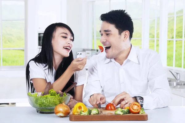 Couple eating salad at kitchen — Stock Photo, Image