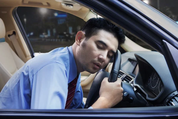 Utmattade arbetaren sover i bilen — Stockfoto