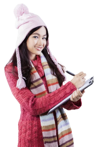 Girl with sweater and clipboard in studio — Stock Photo, Image