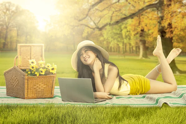 Gelukkige vrouw met laptop ontspannen in herfst park — Stockfoto