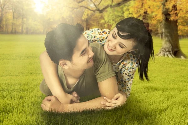 Preciosa pareja acostada en el parque de otoño —  Fotos de Stock