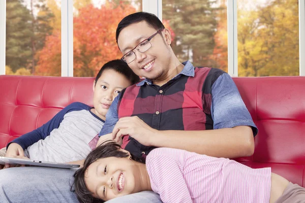 Uomo e i suoi figli con tablet sul divano — Foto Stock