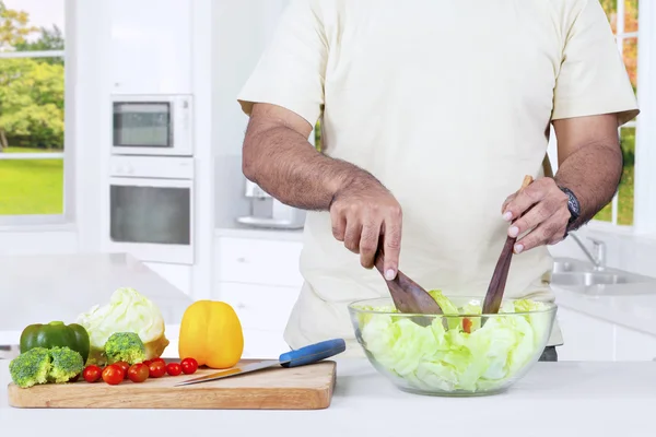 Homme préparant la salade de légumes — Photo