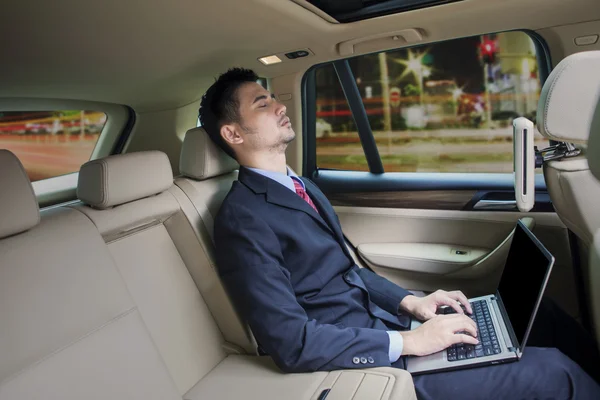 Mannen med laptop sleepin i en bil — Stockfoto