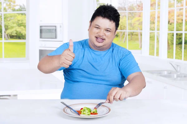 Hombre con sobrepeso muestra el pulgar hacia arriba en la cocina — Foto de Stock