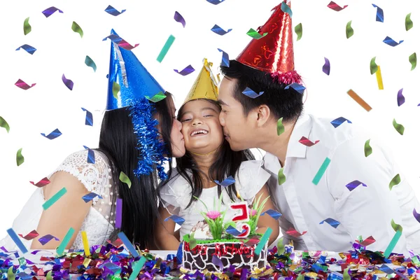 Parents kiss their daughter at birthday party — Stock Photo, Image