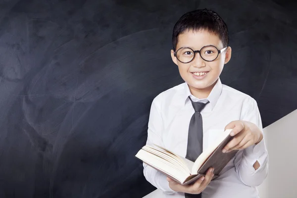 Schoolboy lê livro enquanto está de pé — Fotografia de Stock