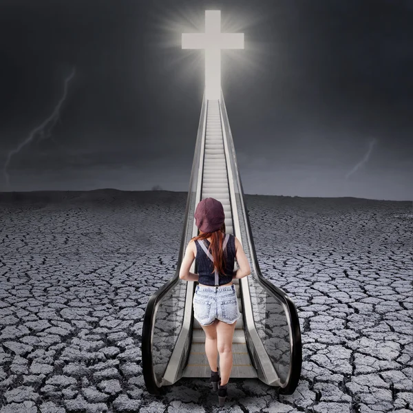 Teenager steigt eine Treppe zum Kreuz hinauf — Stockfoto