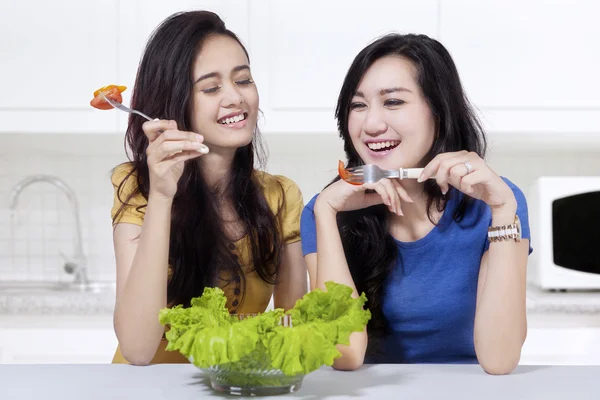 Two girls eating salad together — Stock Photo, Image