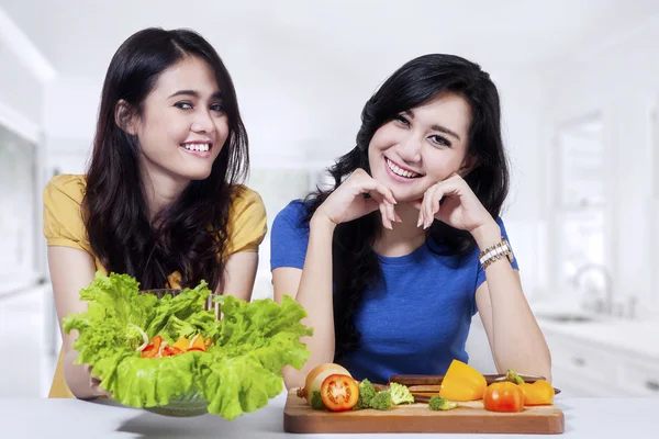 Duas mulheres mostram uma tigela de salada — Fotografia de Stock