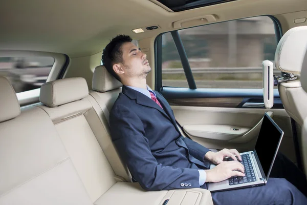 Werknemer met laptop rusten in een auto — Stockfoto