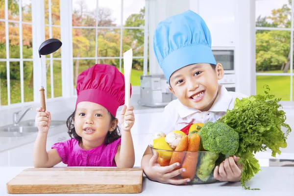 Niños pequeños cocinando comida saludable Fotos de stock libres de derechos