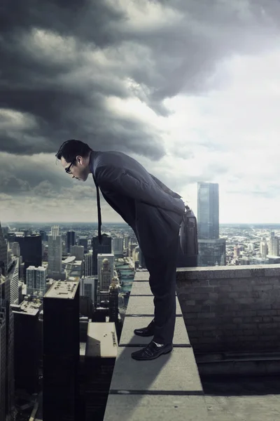 Businessman looking down from the roof — Stock Photo, Image