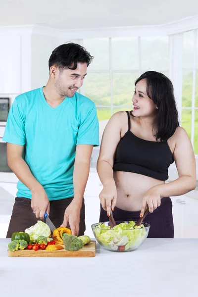 Paar bereitet Salat in Küche zu — Stockfoto